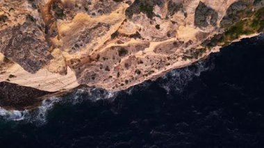 Maltas 'ın derin mavi sularla buluşan dramatik uçurumlarının nefes kesici hava perspektiflerini tecrübe edin. Bu görsel yolculuk, gün batımında adaların doğal güzelliklerini yakalar..