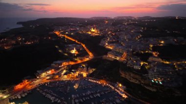 Gün batımında Malta 'nın çarpıcı hava manzarasını izleyin. Canlı renkler kıyı manzarasını ve canlı marinayı aydınlatıyor, adaların doğal güzelliğini ve cazibesini vurguluyor..