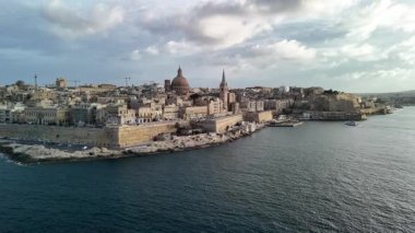 Geniş hava manzaralarıyla Malta 'nın çarpıcı güzelliğini keşfedin zengin tarihini ve kıyı manzaralarını gözler önüne seriyor. Manzarada mimari ve parıldayan Akdeniz yer alıyor..