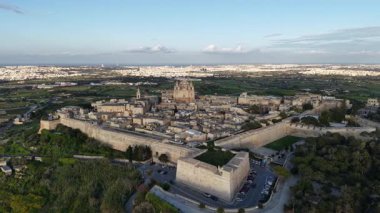 Mdina 'nın nefes kesen manzarasını yukarıdan keşfedin, Malta' daki bu ortaçağ mücevherini çevreleyen fevkalade güçlendirilmiş duvarları, tarihi binaları ve bereketli manzaraları vurgulayın..