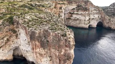 Maltas Blue Grotto 'nun nefes kesici manzarasını keşfedin, dramatik uçurumlar ve berrak mavi sular. Bu kıyı cennetindeki doğal kemerlere ve canlı deniz yaşamına tanık olun..