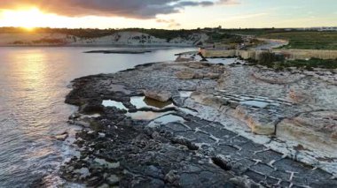 Güneş batarken, engebeli uçurumları ve sakin suları aydınlatan Maltas kıyılarının çarpıcı hava manzarasına tanık olun. Bu eşsiz manzaranın büyüsünü hissedin..