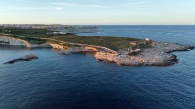Güneş ufukta batarken engebeli uçurumların, sakin suların ve gizli koyların güzelliğini yakalayarak yukarıdan Malta 'nın çarpıcı kıyı şeridini keşfedin..