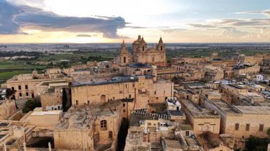 Mdina 'nın büyüleyici şehrini yukarıdan gözlemleyin. Güneş Malta topraklarında batarken antik mimarisini ve bereketli çevresini yakalayın. Göz kamaştırıcı bir görsel manzara yaratın..