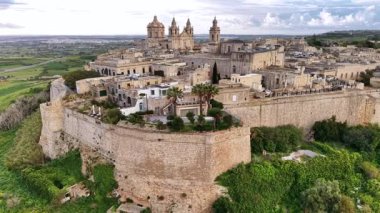 Malta 'nın büyüleyici şehri Mdina' yı keşfedin, tarihi tahkimatlarını, antik binalarını ve çarpıcı bir gökyüzü altında yemyeşil alanlarını sergileyin..