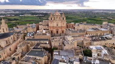 Mdina, Maltas 'ın büyüleyici hava manzarasına tanık olun. Sessiz şehir, görkemli tahkimatlarını ve karmaşık barok mimarisini yemyeşil kırsal bir zemin üzerinde sergiliyor..