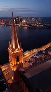 Alacakaranlıkta Malta Valletta 'nın çarpıcı bir hava perspektifini tecrübe edin. Aydınlatılmış mimariye ve parıldayan sahil şeridine hayran kaldım..