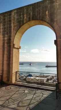 Valletta, Malta 'da güzel bir terasta huzurlu bir anın tadını çıkarın. Parlayan denizi ve parlak gökyüzünün altında yavaşça süzülen tekneleri seyredin..