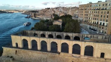 Malta Valletta 'nın kıyı şeridi boyunca uzanan eşsiz mimarinin çarpıcı hava manzarasına tanık olun. Canlı sular bu UNESCO Dünya Mirası sahasının zengin tarihini ve güzelliğini yansıtıyor..