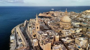 Valletta, Malta 'nın nefes kesici hava perspektifini ele alalım. Işıldayan sularda yüzen tekneler ikonik simgelerini, antik yapılarını ve canlı kıyı manzarasını vurguluyor..
