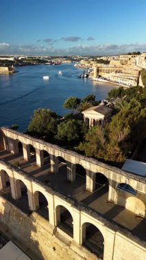 Güneş limanın üzerinde batarken, Malta Valletta 'nın çarpıcı bir hava perspektifini keşfet. Video, şehri çevreleyen zengin tarih ve doğal güzelliğin bir karışımını yakalıyor..