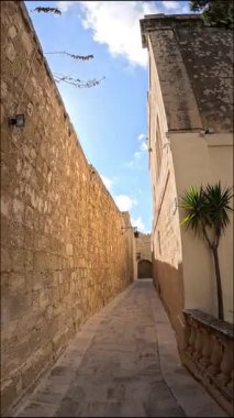 Mdina 'nın tarihi dar sokaklarında dolaş, Malta, antik taş duvarlar ve açık mavi bir gökyüzü ile çevrili. Bu ortaçağ şehrinin cazibesini gün ışığında yaşayın..