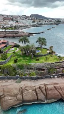 Tenerifes sahil şeridinin nefes kesen manzarasının tadını çıkarın, yemyeşil palmiyeler ve pürüzsüz uçurumlar. Huzurlu atmosfer, bu büyüleyici ada cennetini rahatlatmaya ve keşfetmeye davet ediyor..
