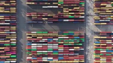 Sabahın erken saatlerinde açık bir gökyüzü sırasında Zeebrugge limanında çeşitli renkli kaplar düzenli olarak düzenlenir. Geniş alan, etkin lojistik işlemlerin devam ettiğini gösteriyor.