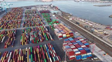 Zeebrugge limanında çeşitli renklerde nakliye konteynerleri düzenlenir. İskele vinçleri konteynırları gündüz yükleme ve boşaltma için yanaştırır. Liman hareketlilik içinde..