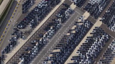 Hava görüntüsü, Zeebrugge 'da düzgün düzenlenmiş araçlarla dolu büyük bir araba depolama tesisi olduğunu gösteriyor. Organize satırlar araba taşımacılığının lojistiğini vurguluyor. Yoğun bir denizcilik merkezi.