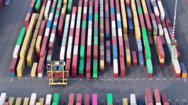 Zeebrugge limanındaki renkli nakliye konteynırlarının kapsamlı yerleşimi lojistik ve ulaşım faaliyetlerinin boyutunu vurguluyor. Kamyonlar sıra sıra hareket ediyor, ihracat için kargo düzenliyorlar..