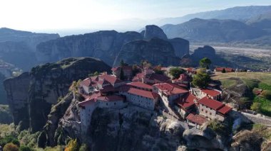 Yunanistan 'ın Meteora kentindeki görkemli hava manzarasına tanık olun. Antik manastırların yükselen kaya oluşumlarının tepesinde, doğal manzara ve dağlarla çevrili..