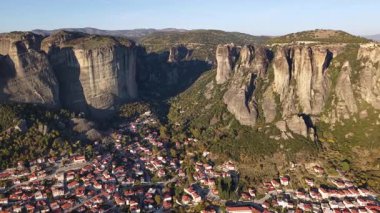 Yunanistan 'daki Meteora' nın olağanüstü güzelliğini hava perspektifinden deneyimlemek, görkemli kaya oluşumlarını göstermek ve aşağıdaki büyüleyici köy.