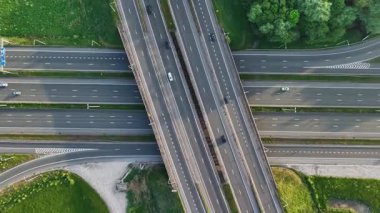 Bruges yakınlarında yel değirmenlerinin yer aldığı yoğun bir kavşağın havadan perspektifini keşfedin. Video, bölgeyi çevreleyen trafik ve yemyeşil alanları yakalıyor ve güzel yerel manzaraları vurguluyor..