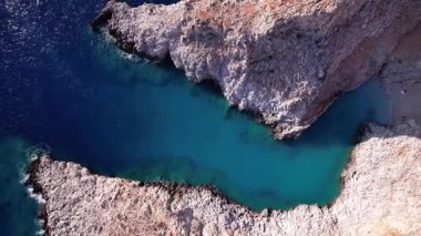 Girit Yunanistan 'daki Seitan Limania plajının nefes kesici hava manzarasına tanık olun. Mavi sular engebeli kayalıklarla buluşarak doğa severler ve maceracılar için mükemmel bir manzara yaratıyor..