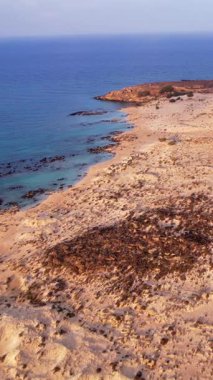 Yunanistan 'ın Girit kentindeki Elafonissi plajının nefes kesici güzelliğini keşfedin. Bu hava manzarası, serinlemek için ideal yumuşak altın kumlarla karşılaşan çarpıcı turkuaz suları vurgular..