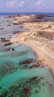 Yunanistan 'ın Girit kentindeki Elafonissi plajının turkuaz sularını ve yumuşak kumlu kıyı şeridini aydınlatan nefes kesici hava manzarasına tanık olun. Bu doğal cennet rahatlamak için mükemmel bir dinlenme yeri sunuyor..