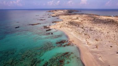 Yunanistan 'ın Girit kentinde, turkuaz suların doğal manzaralarla çevrili yumuşak kumlu kıyılarla buluştuğu Elafonissi plajının çarpıcı güzelliğini deneyimleyin. Bu huzurlu ve huzurlu yerin tadını çıkarın..