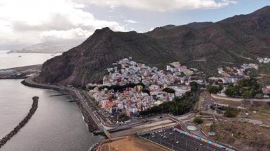 Kanarya Adaları, Tenerife 'nin büyüleyici hava perspektifini deneyin. Genel bakış, dramatik dağlara ve engin okyanusa karşı yuva yapmış renkli bir kıyı kasabasını vurguluyor..