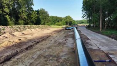 İşçiler ağaçlık bir alanda bir doğalgaz boru hattı inşa etmekle meşgul..