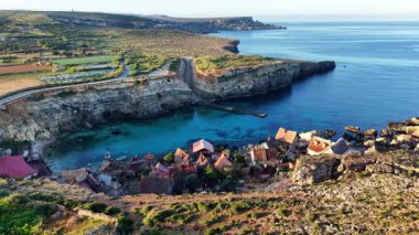 Malta 'da geleneksel bir balıkçı köyünün nefes kesici hava manzarasını keşfedin. Bu büyüleyici manzara kayalık kıyı şeridi boyunca yuva yapmış büyüleyici evleri ve kristal berrak suları gösteriyor..
