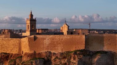 Güneş batarken Gozo Adası 'ndaki Malta Kalesi' nin nefes kesici manzarasını izleyin. Bu hava manzarası bu ikonik kalenin mimari güzelliğini ve zengin tarihini gözler önüne seriyor..