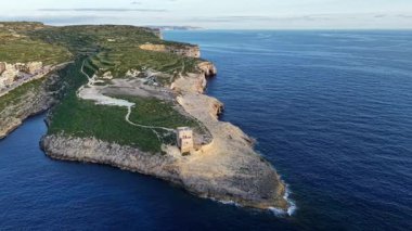 Gökyüzünden Malta 'nın nefes kesici sahil şeridine tanık olun. Dramatik uçurumlar, canlı yeşillikler ve sakin mavi sular sergiliyor. Doğal güzellik gün batımında büyülenir..