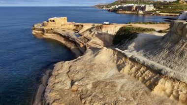 Malta 'nın nefes kesen kıyı manzarasını yukarıdan keşfedin, baş döndürücü uçurumlar, sakin mavi sular ve kıyı boyunca uzanan tarihi mimarinin kalıntıları..