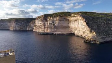 Yukarıdan Malta 'nın nefes kesen uçurumlarını ve gök mavisi sularını keşfedin. Açık gökyüzünün altındaki tarihi mimarinin ve kıyı şeridinin doğal güzelliğini gösterin..