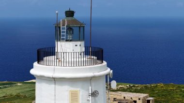 Malta üzerindeki nefes kesici hava perspektifini keşfedin, ikonik deniz fenerini koyu mavi Akdeniz ve bereketli manzaraların arka planına vurguluyor..