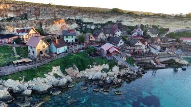Nefes kesici bir hava manzarası günbatımında Malta 'da büyüleyici bir balıkçı köyünün canlı renklerini gözler önüne seriyor..