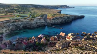 Malta 'daki büyüleyici balıkçı köyünü yukarıdan keşfedin. Resimli evler, canlı bir sahil şeridi ve bu eşsiz yeri tanımlayan dingin mavi sular..
