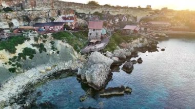 Malta 'da güzel bir balıkçı köyü keşfedin. Kıyı şeridi boyunca antika evler ve gün batımının parıltısıyla aydınlanan güzel kayalık kıyılar..