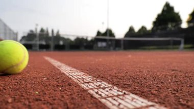 Oyuncular, güzel bir gün batımı arkaplanı ve öğleden sonra canlı bir atmosferi olan yerel parktaki bir kil kortunda heyecanlı bir tenis maçına hazırlanıyorlar..