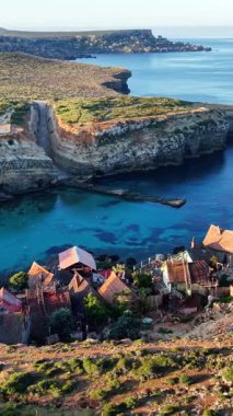 Hava manzarası, Malta 'da nefes kesici uçurumlar ve berrak mavi suların arasına kurulmuş ilginç bir balıkçı köyünün cazibesini yakalıyor. Tekneler limanı dolduruyor, huzurlu manzarayı güzelleştiriyor..