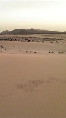 Experience the stunning beauty of Fuerteventuras iconic sand dunes as the sun sets. The landscape showcases the natural wonders of this unique island, offering tranquility and breathtaking views.