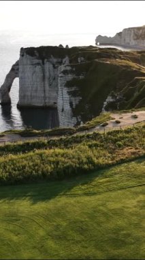 Gün batımının sıcacık parıltısıyla aydınlanan Etretat 'ın ikonik uçurumlarının çarpıcı manzarasının tadını çıkarın. Normandy 'nin kıyı şeridinin ve yemyeşil alanının doğal güzelliğine tanık olun..