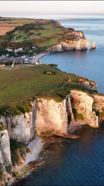 Güneş Normandiya 'nın sakin sularının üzerinde batarken Etretat' ın nefes kesici uçurumlarına hayret ediyorum. Bu sahil taşı inanılmaz manzaralar ve doğal harikalar sunuyor..