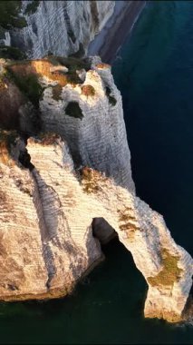 Günbatımında Normandiya 'daki Etretat' ın nefes kesici uçurumlarını, çarpıcı kaya oluşumlarını ve dramatik kıyı şeridini deneyimleyin. Bu manzaralı yerde doğa güzelliği parlıyor..