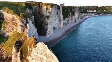 Güneş Normandiya kıyısında batarken Etretat 'ın nefes kesici uçurumlarına tanık olun. Doğal güzellik ve sahil cazibesiyle dolu huzurlu bir an bizi bekliyor..