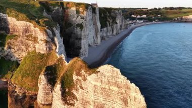 Güneş Normandiya 'da Etretat' ın üzerinde batarken ikonik kayalıkların ve sakin plajların nefes kesici manzarasını tecrübe edin. Doğal güzellik ve sahil cazibesi keşfedilmeyi bekliyor..