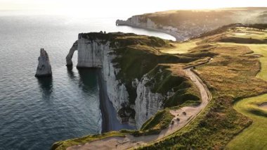 Nefes kesen uçurumlar, Fransa 'nın Etretat kentindeki İngiliz Kanalı' nın sakin sularına tepeden bakıyor. Güneş batarken, bu güzel sahil kasabasının üzerine ılık bir parıltı saçıyor..