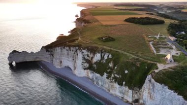 Altın bir günbatımında Normandiya 'daki Etretat' ın nefes kesici uçurumlarını keşfedin. Bu ikonik konumun sunduğu sakin plajı, bereketli yeşilliği ve kıyı güzelliğini deneyin..