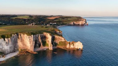 Fransa 'nın Etretat kentinin nefes kesici güzelliğini yaşayın. Huzurlu altın saat boyunca ikonik beyaz uçurumlarını ve sakin sahil manzaralarını sergileyin. Doğa başyapıtı bekliyor..